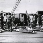 a group of men standing around a group of dead people