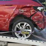 a red car is on a flatbed tow truck