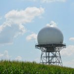 Weather radar dome on a hill with clouds